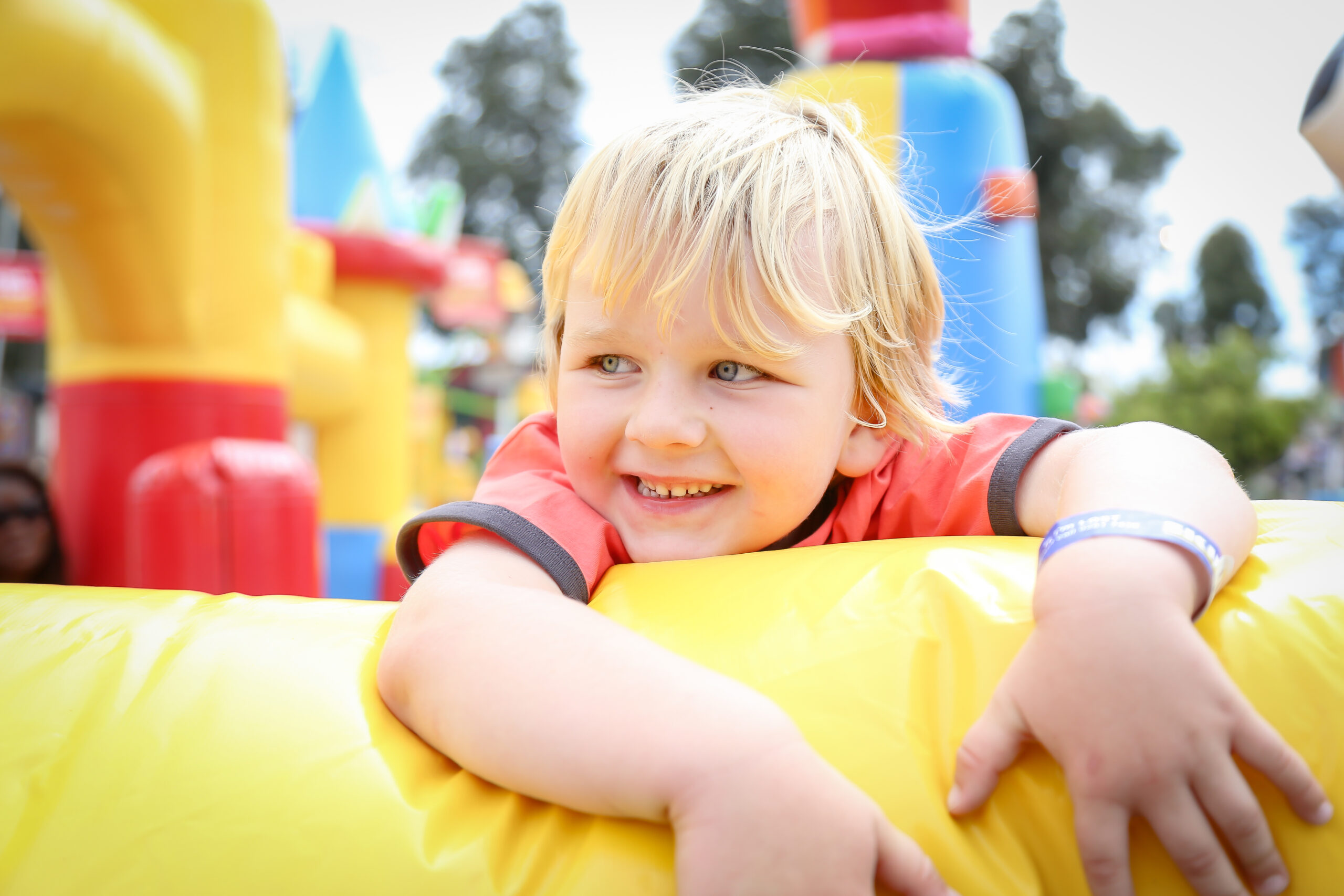 A happy adorable blonde Australian kid happily posing white standing in trampoline